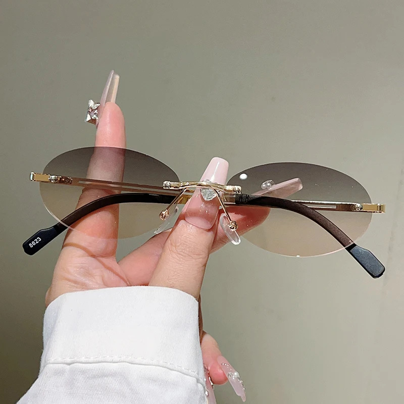 Designer Sunglasses - フレームレスのオーバル型サングラス。女性向け、グラデーションレンズ、装飾が施されたデザイン。最新トレンドのヴィンテージブランド、カジュアルなメガネ。